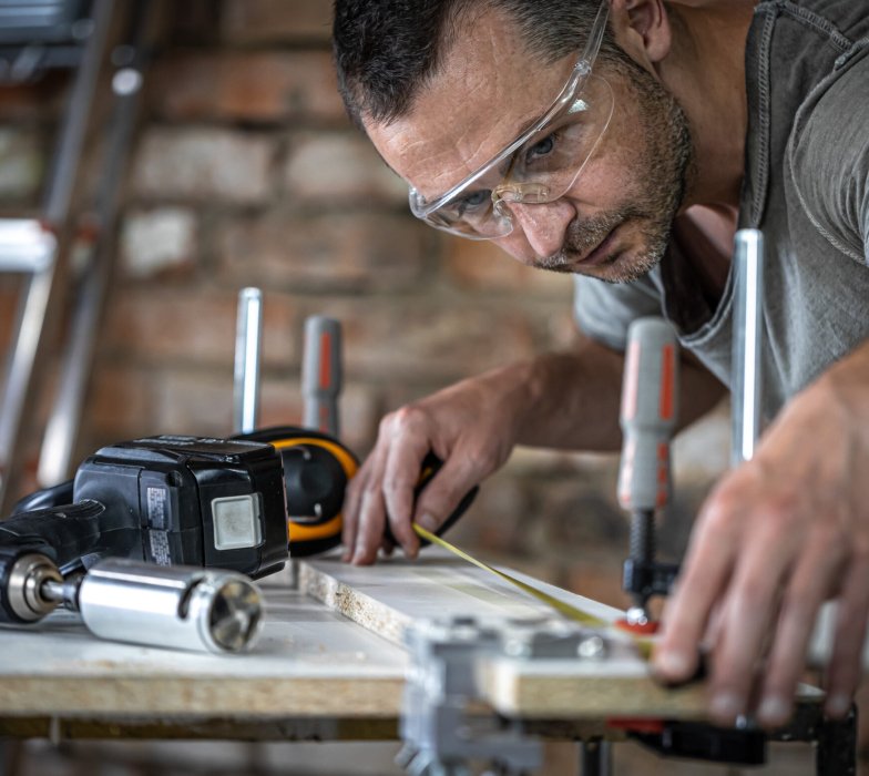 A carpenter in the process, a professional tool for precision drilling in wood.